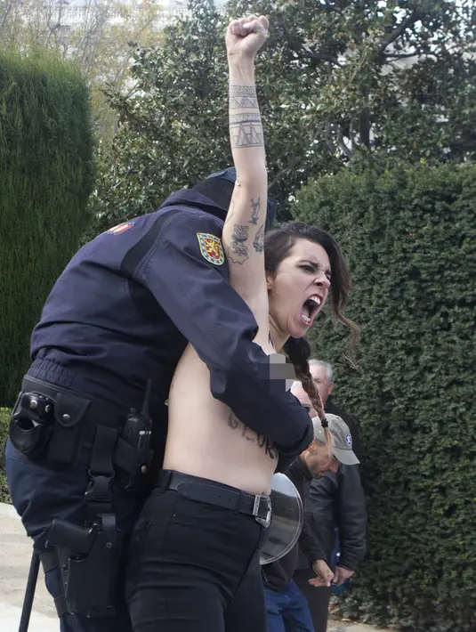 Aktivis Femen ditangkap polisi saat melakukan aksi telanjang dada memprotes penggalian makam diktator Spanyol Francisco Franco selama pertemuan tahunan di Madrid, Spanyol (24/11/2019). Aksi ini sekaligus memperingati kematian ke-44 Francisco Franco. (AP Photo/Paul White)