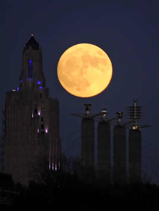 Fenomena Supermoon berada di dekat bangunan Power dan Light di Kota Kansas, Missouri, AS (13/11). Fenomena ini merupakan bulan paling besar dan terang dalam kurun 70 tahun terakhir. (REUTERS/Dave Kaup)