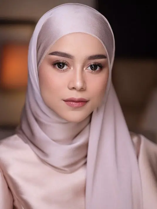 Ia pun nampak memesona dengan kerudung ungu dan busana warna rose gold. (@lestykejora)