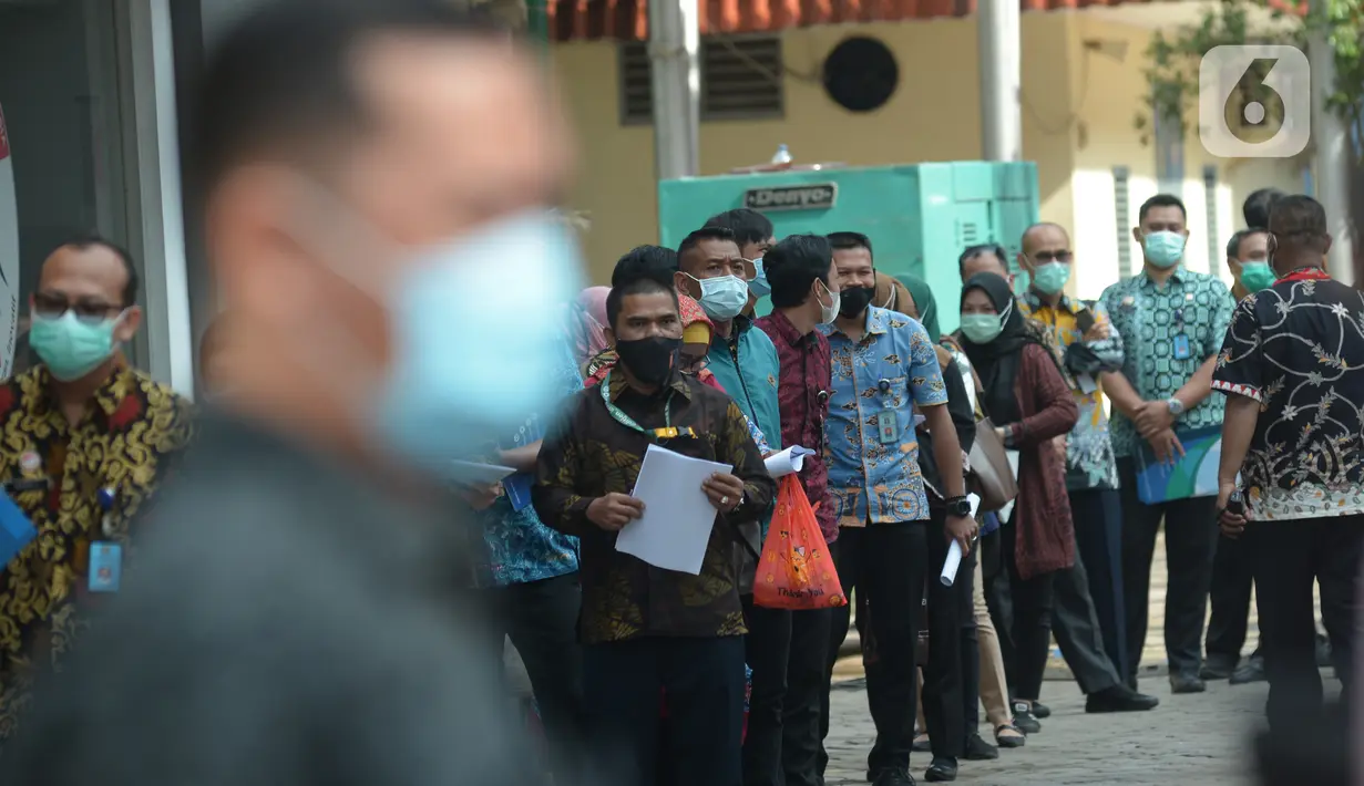 Pekerja mengantre mengikuti vaksinasi massal Covid-19 di lingkungan kerja Kemenkumham, Jumat (12/3/2021). Sebanyak 1000 an lebih vaksin yang di berikan untuk Ditjen Imigrasi Kemenkumham sebagai salah satu upaya dalam rangka pencegahan dan penanggulangan Covid-19. (merdeka.com/Imam Buhori)
