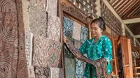 Ilustrasi perempuan sedang melihat-lihat kain batik/copyright shutterstock.com/Odua Images