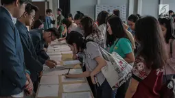 Para peserta melakukan registrasi acara Emtek Goes To Campus (EGTC) 2018 di Universitas Kristen Petra, Surabaya, Rabu (14/11). Bertempat di Auditorium Kampus Timur, EGTC 2018 ini berlangsung hingga 15 November mendatang. (Liputan6.com/Faizal Fanani)