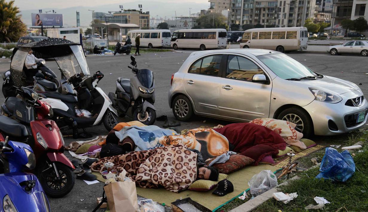 Sementara, ratusan lainnya mengalami luka-luka. Tampak dalam foto, para pengungsi yang melarikan diri dari serangan udara Israel di Dahiyeh, pinggiran selatan Beirut, tidur di Lapangan Martir di pusat kota Beirut, Lebanon, Sabtu 7 Maret 2026. (AP Photo/Bilal Hussein)
