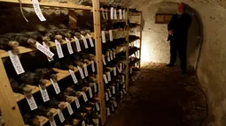 Petugas keamanan berdiri di samping rak botol anggur abad ke-19 di ruang bawah tanah dari Becov kastil di Becov nad Teplou, Republik Ceko, (22/5/2016).  (REUTERS/David W Cerny)