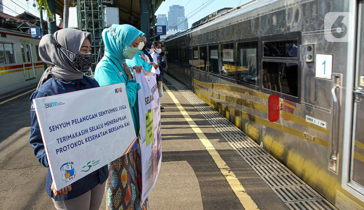 Petugas memberikan salam kepada penumpang saat KA Taksaka berangkat dari Stasiun Gambir, Jakarta, Sabtu (4/8/2021). Dalam rangka memperingati hari pelanggan nasional, PT KAI Daop 1 Jakarta membagikan ratusan bingkisan kepada penumpang kereta api. (Liputan6.com/Faizal Fanani)