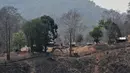 Foto kombinasi menunjukkan pangkalan militer Myanmar terbakar usai diserang pemberontak etnis Karen di tepi Sungai Salween terlihat dari Mae Sam Laep, Mae Hong Son, Thailand, 27 April 2021 (atas) dan pangkalan yang sama pada 31 Maret 2021 (bawah). (Handout, Lillian SUWANRUMPHA/AFP/KAWTHOOLEI TODAY)