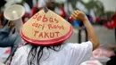Massa memakai topi caping bertuliskan 'Bebas Rasa Takut' saat aksi tolak hukuman mati yang bersamaan dengan peringatan Hari Buruh (May Day) di depan Istana Merdeka, Jumat (1/5/2015). (Liputan6.com/Faizal Fanani)