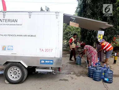 Sebuah mobil instalasi pengolahan air Kementerian PUPR mendistribusikan air untuk kebutuhan pengungsi korban gempa dan tsunami Palu di halaman kantor Wali Kota Palu, Sulawesi Tengah, Senin (8/10). (Liputan6.com/Fery Pradolo)