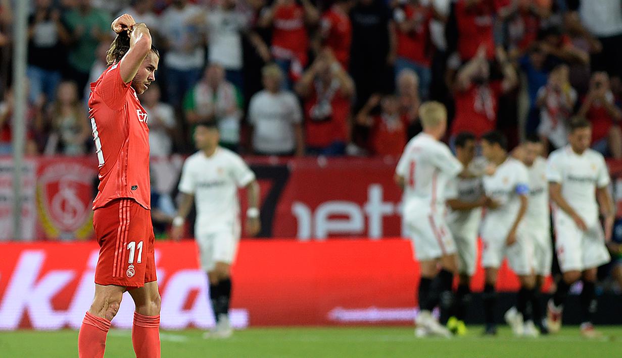 Gelandang Real Madrid, Gareth Bale terlihat kecewa setelah striker Sevilla Andre Silva mencetak gol pada pertandingan lanjutan La Liga Spanyol di stadion Sanchez Pizjuan (26/9). Sevilla mengalahkan Madrid dengan skor 3-0. (AFP Photo/Cristina Quicler)