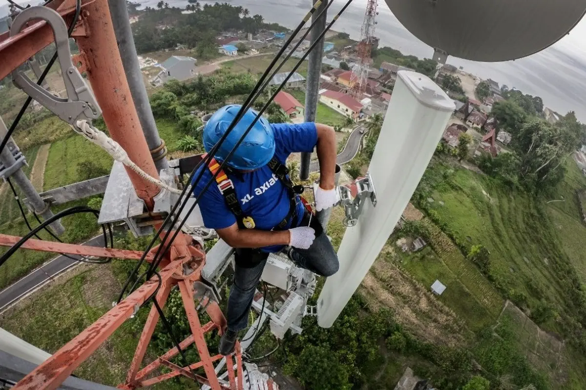 Petugas jaringan XL memeriksa menara BTS XL Axiata yang ada di Danau Toba, Parapat, Sumatera Utara