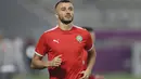 Bek Maroko, Romain Ghanem Saiss melakukan pemanasan dalam sesi latihan jelang menghadapi Prancsi di babak semifinal Piala Dunia 2022  di Stadion Al Duhail SC di Doha pada 13 Desember 2022. Maroko berhasil lolos ke semifinal usai menyingkirkan Portugal dengan skor 1-0 pada babak perempat final. (AFP/Karim Jaafar)