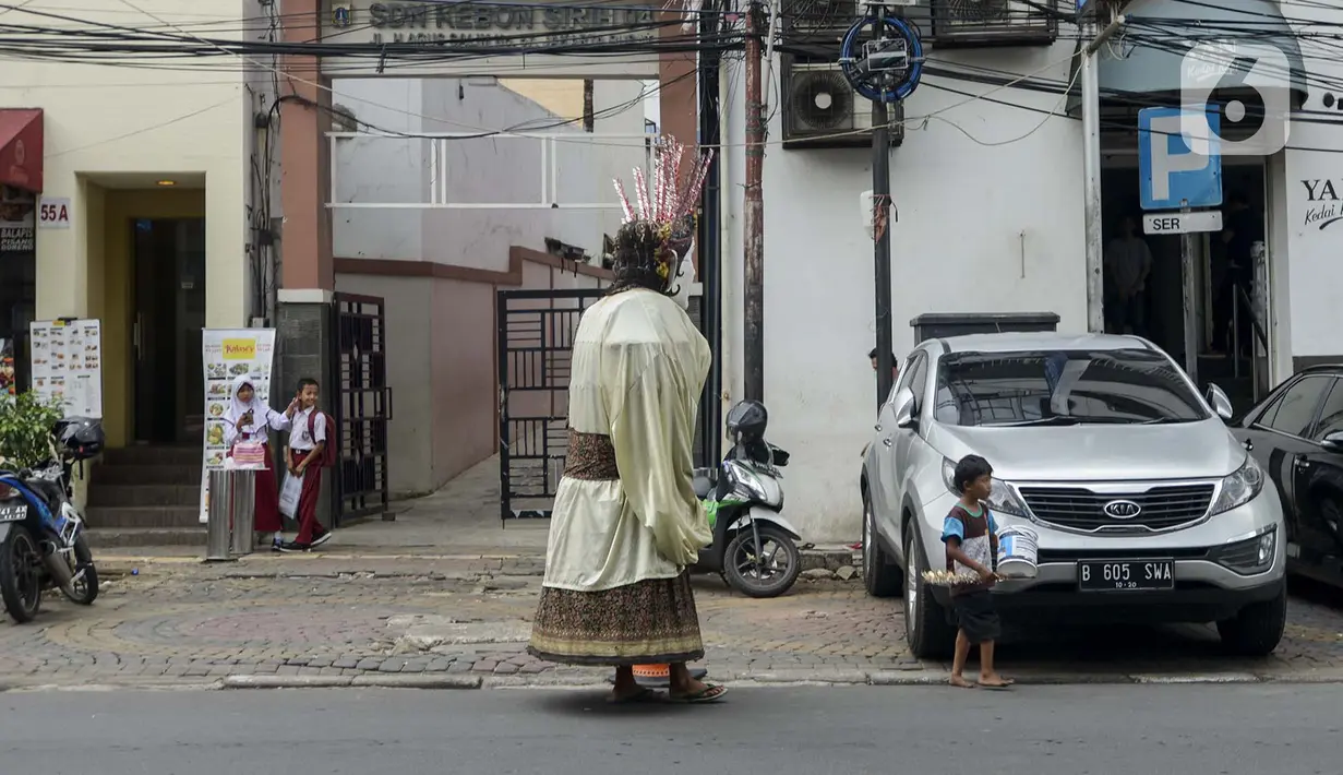 Pengamen ondel-ondel berkeliling di kawasan Sabang, Jakarta, Selasa (11/2/2020). DPRD DKI Jakarta berencana merevisi Perda Nomor 4 Tahun 2015 tentang Pelestarian Kebudayaan Betawi. Revisi ini bertujuan untuk melarang penggunaan ondel-ondel sebagai alat mengamen. (merdeka.com/Imam Buhori)