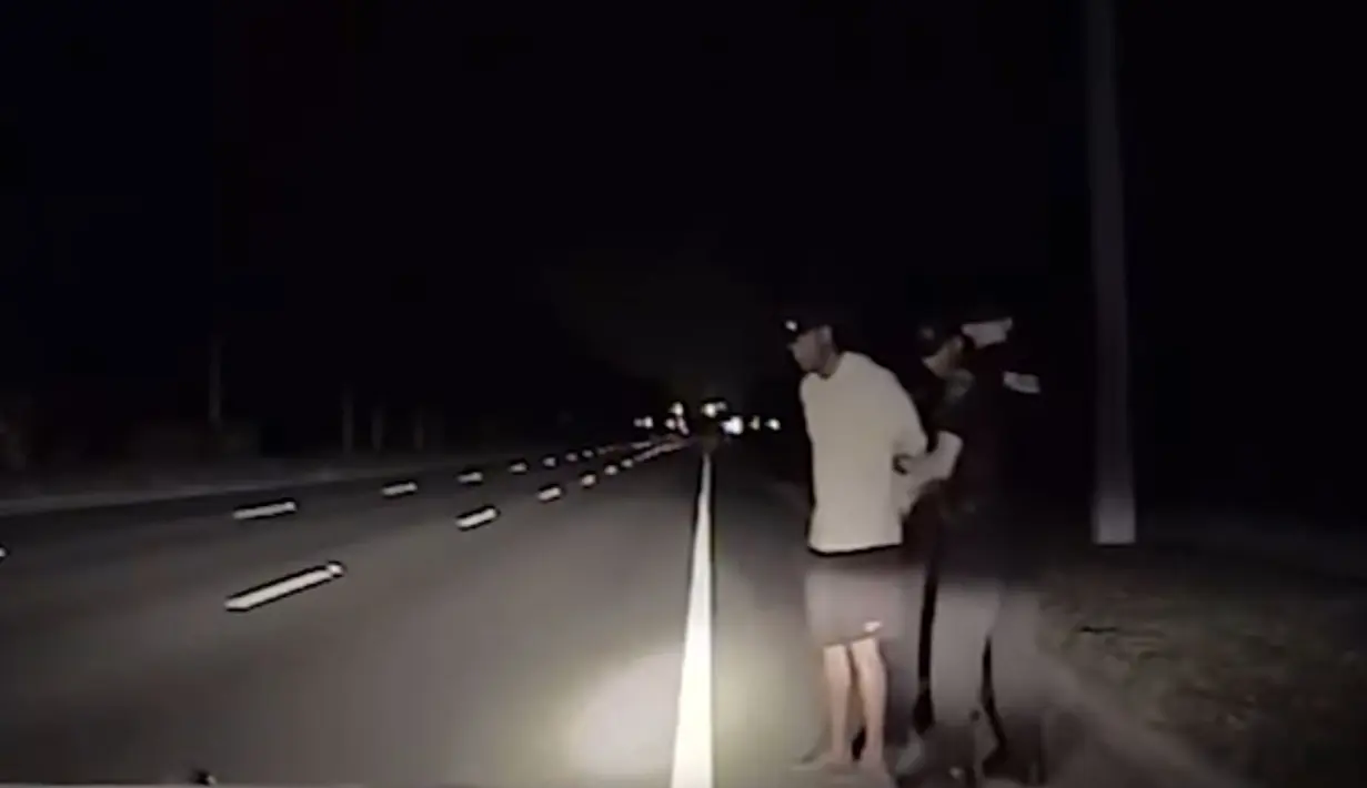 Gambar yang direkam otomatis via perangkat di mobil polisi menunjukkan polisi Jupiter, Florida, melaksanakan tes mabuk kepada Tiger Woods, 29 Mei 2017. Dalam video menunjukkan Woods berada dalam pengaruh zat tertentu. (HO/ Jupiter Police Department/AFP)