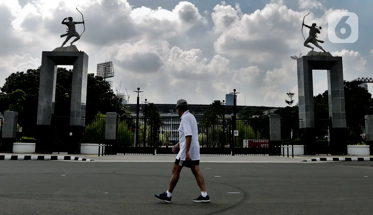 Seorang pria dengan mengenakan masker berolahraga selama pemberlakuan Pembatasan Sosial Berskala Besar (PSBB) di Kawasan Senayan, Jakarta, Kamis (16/4/2020). Kendati Kawasan Senayan pun juga diterapkan PSBB, warga bisa tetap berolahraga di Komplek Gelora Bung Karno (GBK). (Liputan6.com/Johan Tallo)