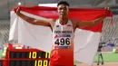 Sprinter Indonesia, Lalu Muhammad Zohri mengibarkan bendera Merah Putih seusai mengikuti kategori 100 meter dalam semifinal Kejuaraan Atletik Asia di Doha, Qatar, Senin (22/4/2019). Lalu Muhammad Zohri sukses menggondol medali perak setelah membukukan catatan waktu 10,13 detik. (AP/Vincent Thian)