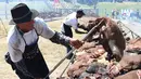 Peserta membalikan daging sapi yang sedang dipanggang di Taman Rodo di Minas, Uruguay (10/12). Dengan daging sebanyak 16.500 kg, mereka berusaha memecahkan rekor dunia dengan katagori  "The World's Biggest Barbecue". (AFP Photo/Miguel Rojo)