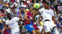 Pemain Barcelona Sergio Aguero (tengah) berebut bola dengan pemain Real Madrid David Alaba pada pertandingan La Liga Spanyol di Stadion Camp Nou, Barcelona, Spanyol, Minggu (24/10/2021). Real Madrid menang 2-1. (AP Photo/Joan Monfort)