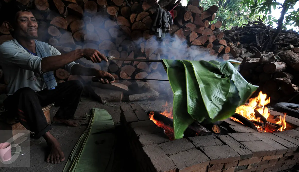 Foto yang diambil 23 Januari 2016 memperlihatkan pekerja tengah membakar daun pisang yang akan digunakan untuk membungkus kue keranjang di pabrik Nyona Lauw di Neglasari, Tangerang. (Liputan6.com/JohanTallo)