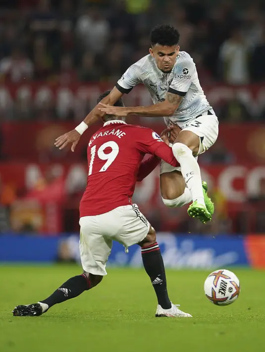 Penyerang Liverpool Luis Diaz dilanggar oleh bek Manchester United Raphael Varane pada laga pekan ketiga Liga Inggris di Stadion Old Trafford, Selasa (23/8/2022) dini hari WIB. Secara luar biasa MU menang perdana di Liga Inggris musim 2022/2023 dengan mengalahkan rival abadi Liverpool 2-1. (AP Photo/Dave Thompson)