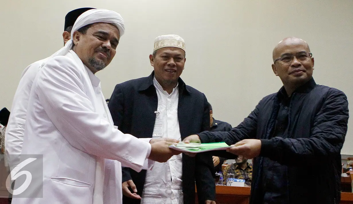 Habib Rizieq Shihab bersama sejumlah tokoh GNPF MUI menyerahkan laporan kepada Wakil Ketua Komisi III DPR Desmond J Mahesa (kanan) saat mendatangi Komisi III di Kompleks Parlemen Senayan, Jakarta, Selasa (17/1). (Liputan6.com/JohanTallo)