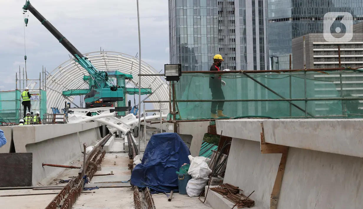 Pekerja beraktivitas menyelesaikan pengerjaan Stasiun LRT Jabodebek Dukuh Atas, Jakarta, Minggu (29/11/2020). Saat ini progres pembangunan LRT Jabodebek sudah mencapai 79,52 persen dan ditarget akan beroperasi pada pertengahan 2022. (Liputan6/Helmi Fithriansyah)