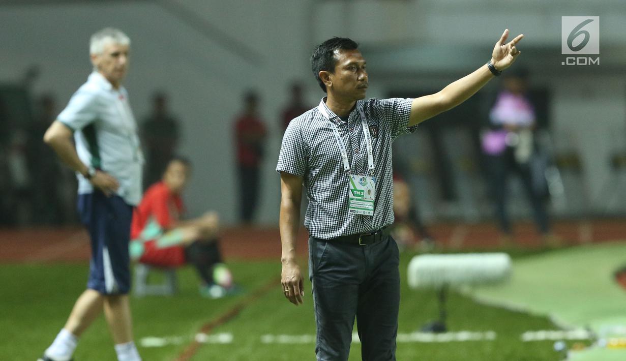 Pelatih Bali United, Widodo C Putro (kanan) memberi arahan pada pemainnya saat laga melawan PS TNI dilanjutan Liga 1 Indonesia di Stadion Pakansari, Kab Bogor, Senin (10/7). Laga dimenangkan Bali United dengan 4-3. (Liputan6.com/Helmi Fithriansyah)