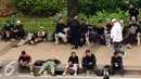 Massa aksi damai beristirahat dan tidur di pinggir Jalan Merdeka Barat, Jakarta, Jumat (4/11). Massa melakukan aksi di depan Istana Negara menuntut penegakan hukum kasus dugaan penistaan agama. (Liputan6.com/Helmi Fithriansyah)