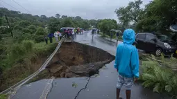 Jalan yang runtuh akibat banjir akibat hujan lebat menyusul topan Freddy di Blantyre, Malawi, pada 13 Maret 2013. Pemimpin Malawi pada 13 Maret 2023 mengumumkan keadaan bencana di beberapa distrik selatan termasuk komersial hub Blantyre setelah topan kuat Freddy kembali menawaskan ratusan orang. (AFP/Amos Gumulira)