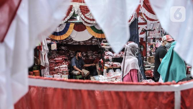 Pedagang menunggu pembeli pernak-pernik Hari Kemerdekaan di Pasar Jatinegara, Jakarta, Minggu (2/8/2020). Menjelang perayaan HUT ke-75 Republik Indonesia, Pasar Jatinegara mulai dipadati warga yang ingin mencari beragam pernak-pernik hiasan kemerdekaan. (merdeka.com/Iqbal Nugroho)