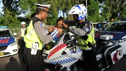 Polisi menempelkan stiker bendera Indonesia dan Arab Saudi selama persiapan menyambut Raja Arab Saudi Salman bin Abdulaziz,Nusa Dua, Bali (2/3). Raja Salman dan rombongan yang terdiri dari 1.500 orang berlibur di Bali. (AFP Photo / Sonny Tumbelaka)