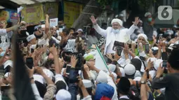 Rizieq Shihab menyapa massa pendukungnya saat tiba di kediamannya di Jalan Petamburan, Jakarta, Selasa (10/11/2020). Rizieq Shihab tiba di kediamannya usai pulang dari Arab Saudi. (merdeka.com/Imam Buhori)