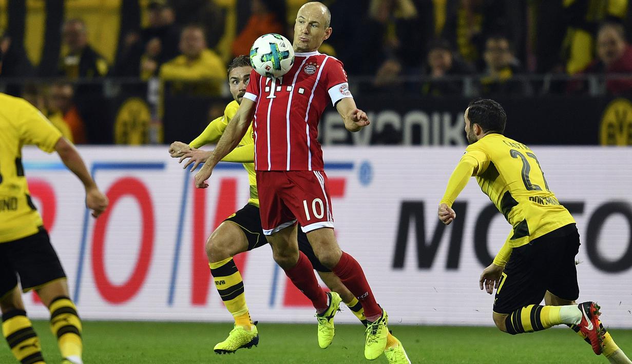 Pemain Bayern, Arjen Robben (tengah) menahan bola saat mengecoh para pemain Dortmund pada lanjutan Bundesliga di Signal Iduna Park, Dortmund, (4/11/2017). Bayern menang 3-1. (AP/Martin Meissner)
