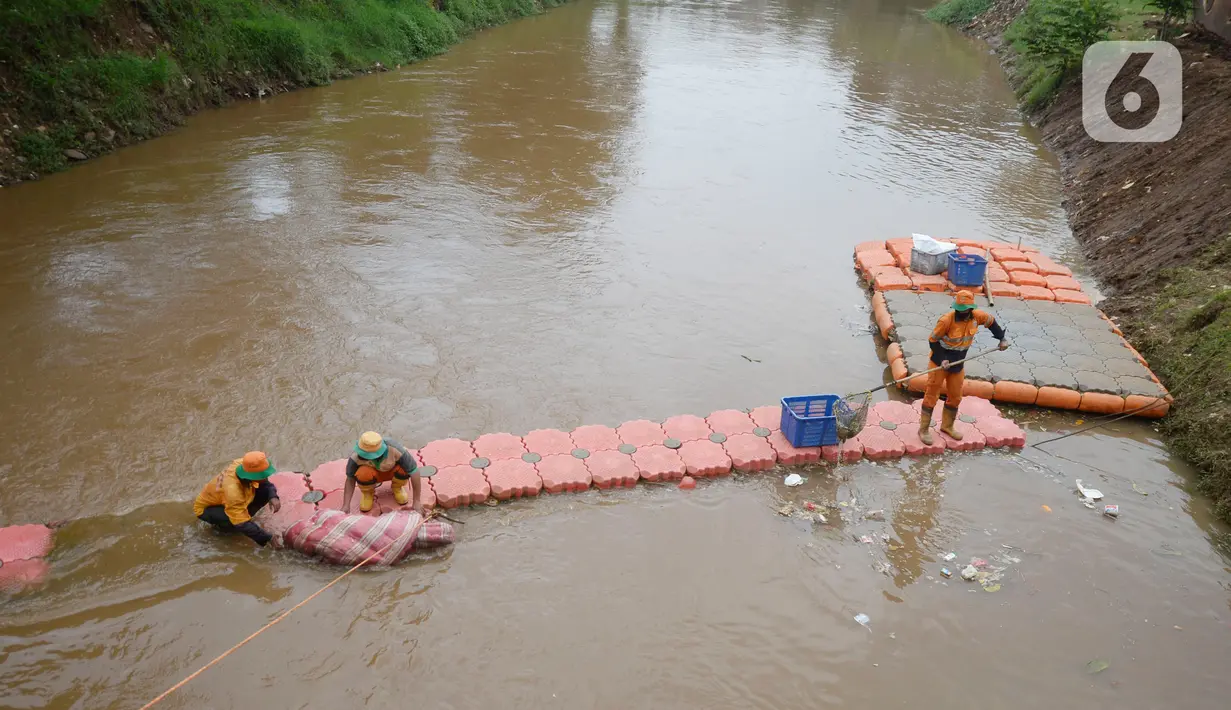 Pekerja Dinas Kebersihan mengangkat sampah kasur di Kali Pesanggrahan, Jakarta Selatan, Rabu (4/11/2020). Sampah-sampah yang terbawa arus air terjaring di penyaringan sampah yang dipasang untuk mengantisipasi penyumbatan pada musim penghujan bisa terjadi banjir. (merdeka.com/Dwi Narwoko)