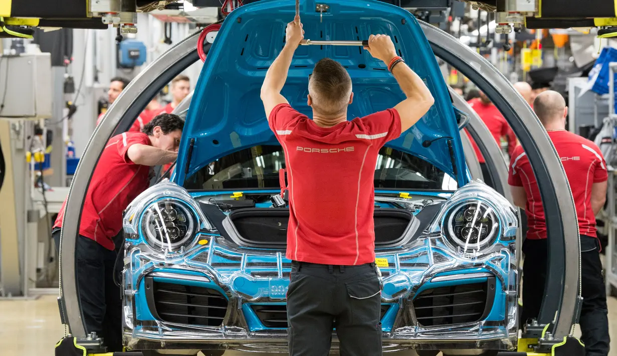 Karyawan bekerja merakit mobil sport Porsche 911 di pabrik Porsche di Stuttgart, Jerman (26/1). sebanyak 21 ribu karyawan akan mendapatkan bonus dengan nilai yang sama, yaitu 9.111 euro atau lebih dari Rp 130 juta. (AFP Photo/Thomas Kienzle)