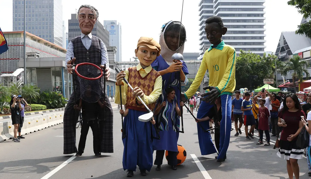 Empat boneka asal Prancis dari Kelompok teater Les Grandes Personnes hibur warga saat CFD di Jakarta, Minggu (9/7). Kegiatan untuk menghimpun dana akan disalurkan ke sejumlah yayasan  di bidang pendidikan anak. (Liputan6.com/Immanuel Antonius)