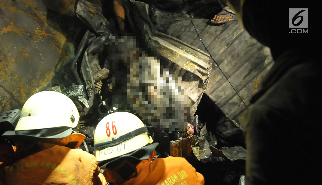 Petugas menemukan dua jasad yang sudah hangus terbakar di dalam puing minibus yang ringsek usai  kecelakaan kereta api di perlintasan Kramat, Senen, Jakarta, Selasa (13/6). (Liputan6.com/Helmi Afandi)