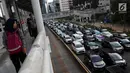 Pejalan kaki melihat kemacetan di Jalan Sudirman-Thamrin, Jakarta, Kamis (20/12). Sejumlah tranportasi multi moda yang sedang dibangun yakni commuter line, MRT, LRT, bus rapid transit (BRT). (Liputan6.com/JohanTallo)