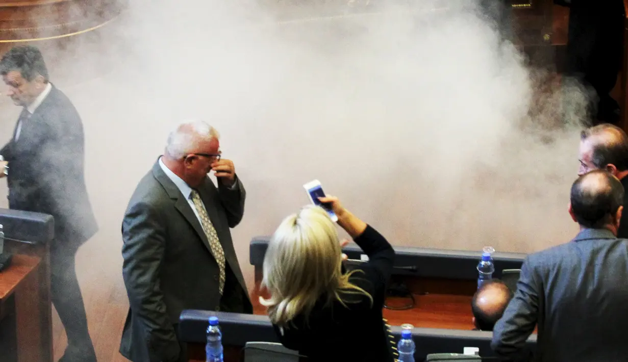 Sejumlah anggota parlemen Kosovo berhamburan saat asap menutupi ruang sidang di Kosovo, Kamis (15/10/2015). Partai oposisi meminta Pemerintah membatalkan kebijakannya, karena dinilai membahayakan integritas Kosovo. (REUTERS/Hazir Reka) 