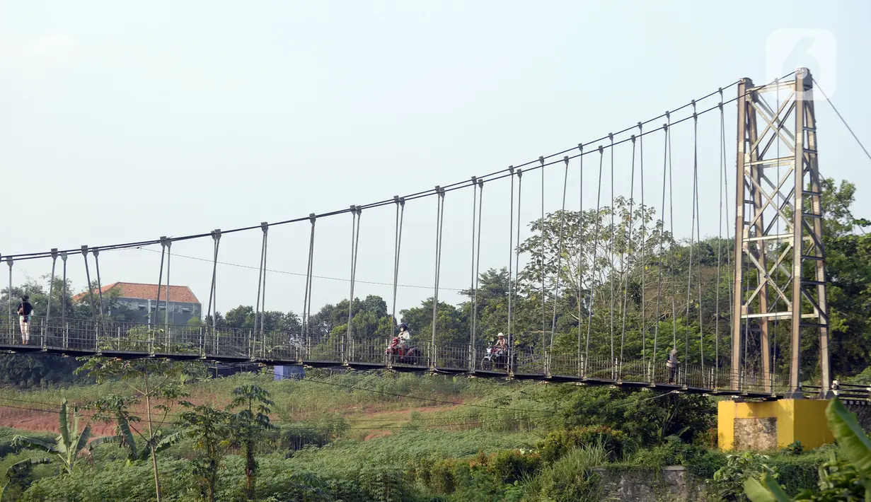 Suasana jembatan gantung di Kelurahan Curug, Bojongsari, Kota Depok, Jawa Barat, Senin (24/8/2020). Setiap sore, warga sekitar bermain di jembatan tersebut sambil menikmati matahari tenggelam. (merdeka.com/Dwi Narwoko)