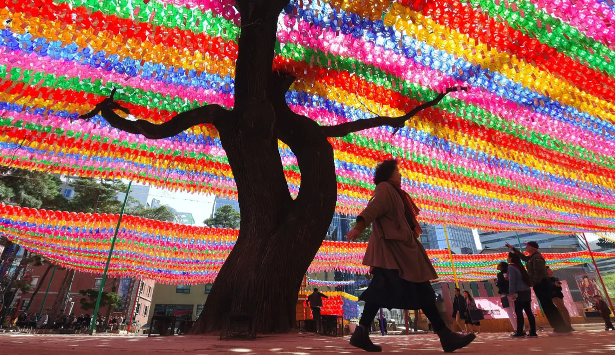 Pengunjung melihat lampion yang terpasang di Jogye Temple jelang perayaan ulang tahun Buddha, Seoul, Rabu (12/4). ‘Lotus Lantern Festival’ menjadi salah satu perayaan yang ditunggu-tunggu oleh warga Korea Selatan. (AFP PHOTO / JUNG Yeon-Je) 