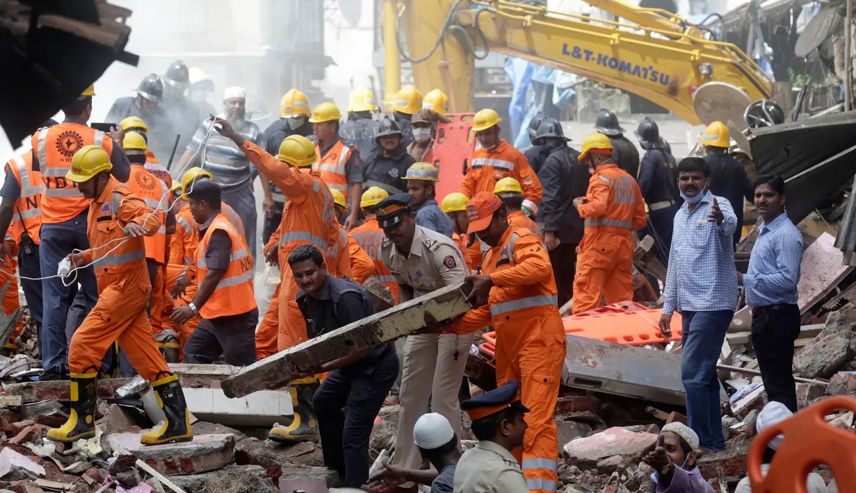 Petugas penyelamat berusaha mencari korban yang tertimbun akibat runtuhnya bangunan di Mumbai, India (31/8). Hampir setiap tahun, puluhan orang tewas akibat bangunan runtuh di India. (AP Photo / Rafiq Maqbool)