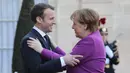 Presiden Prancis Emmanuel Macron (kiri) menyambut Kanselir Jerman Angela Merkel saat tiba di Istana Presiden Eylsee di Paris (16/3). Prancis ingin agar Uni Eropa menggunakan anggaran lebih besar untuk menggerakkan ekonomi. (AFP Photo/Ludovic Marin)