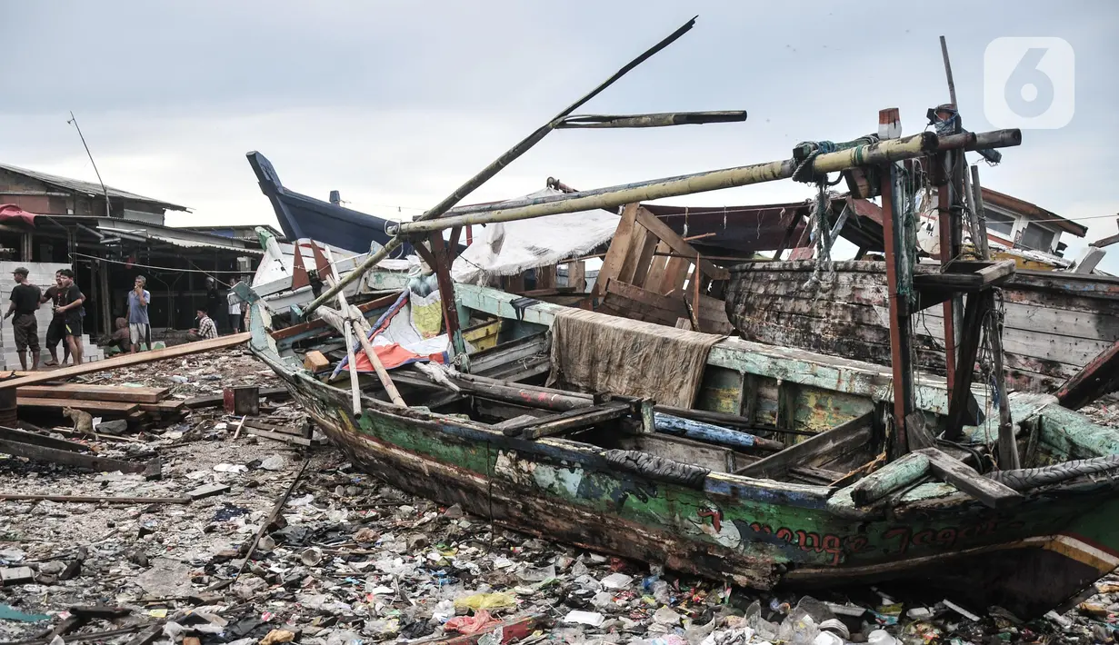 Aktivitas warga dekat tumpukan sampah yang terbawa arus laut di permukiman nelayan Cilincing, Jakarta Utara, Rabu (8/6/2022). Jumlah sampah di laut Nusantara secara keseluruhan diperkirakan sudah mencapai 5,75 juta ton. (merdeka.com/Iqbal S. Nugroho)