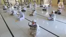 Sejumlah santri berusia belasan tahun membaca Al quran atau tadarus bersama-sama dengan menerapkan jaga jarak di Masjid Daarul Qu'ran Pesantren Al Kautsar, Cibinong, Bogor, Kamis (7/5/2020). Kegiatan Khatam Al quran tersebut dilakukan rutin di setiap bulan Ramadan. (merdeka.com/Arie Basuki)