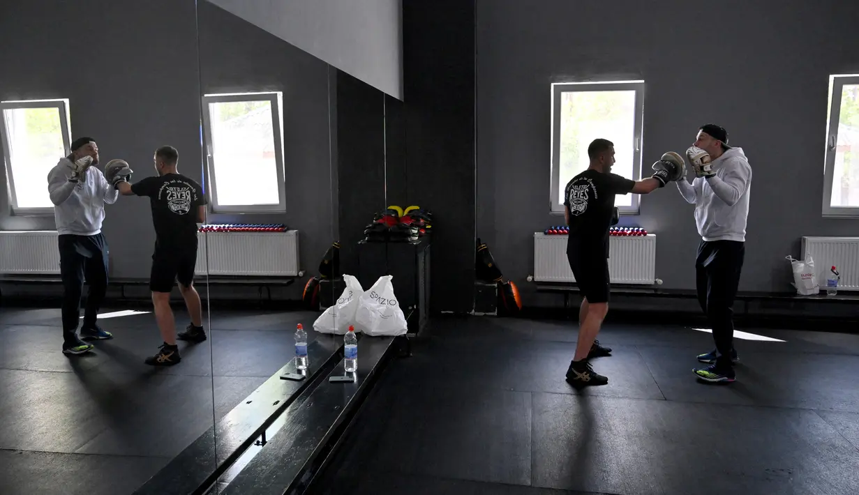 Petinju amatir berlatih di All Stars Boxing Club, Kiev, Ukraina, 10 Mei 2022. Suara hip hop bercampur dengan bunyi pukulan tinju saat sekelompok petinju melepaskan stres terpendam di tengah perang Ukraina. (Sergei SUPINSKY/AFP)