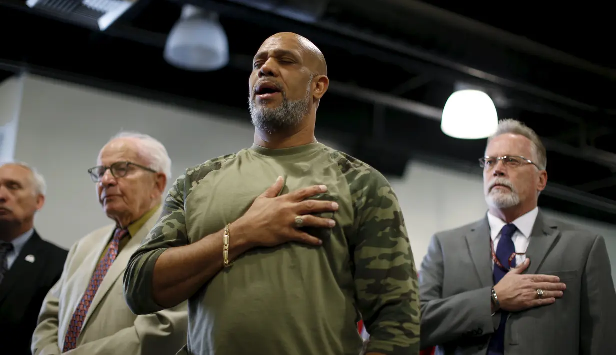 Warga menyanyikan lagu kebangsaan Amerika Serikat dalam perayaan Hari Veteran di penampungan tunawisma Midnight Mission di Los Angeles, Rabu (11/11). Hari Veteran adalah hari libur nasional untuk menghormati jasa tentara Amerika. (REUTERS/Lucy Nicholson)