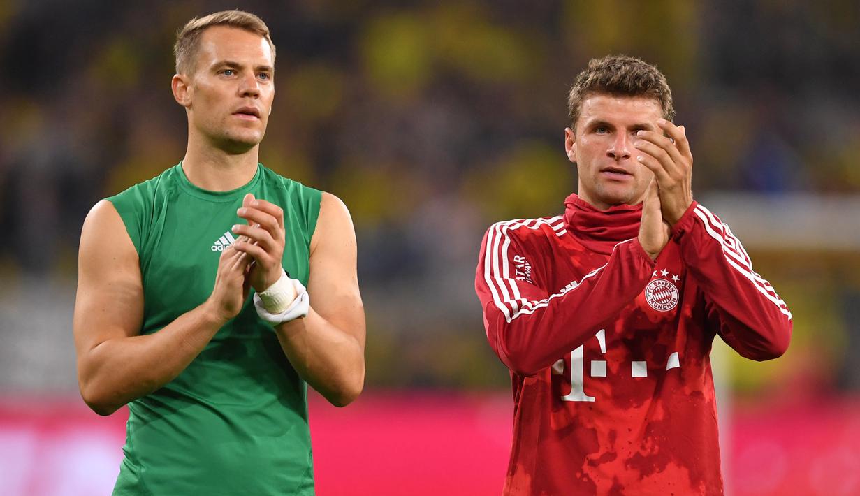 Pemain Bayern Munchen, Manuel Neuer dan Thomas Mueller menyapa suporter usai dikalahkan Dortmund pada laga Piala Super DFL di Stadion Signal Iduna, Dortmund, Sabtu (3/8). Dortmund menang 2-0 atas Munchen. (AFP/Ina Fassbender)