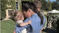 Meghan Markle menggendong dua anaknya,&nbsp;Putri Lilibet dan Pangeran Archie, di rumah mereka di Santa Barbara, Amerika Serikat (AS). (dok. tangkapan layar video Netflix)