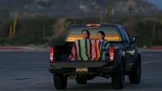 Pasangan muda berselimut menikmati keindahan matahari terbenam duduk di belakang mobil di Cardiff, California (27/1/2016). Wilayah Selatan California ini usai di landa Badai El Nino. (REUTERS/Mike Blake)