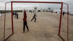 Seorang anak pengungsi Suriah menjaga gawangnya saat bermain sepak bola di sebuah kamp di al-Bil, timur dari kota Azas yang dikuasai pemberontak di Suriah utara (21/4). (AFP Photo/Sameer Al-Doumy)